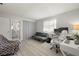 Bright bedroom with hardwood floors, futon, and office setup featuring a modern chair and dual monitors at 2016 Culberson Ave, Dunedin, FL 34698