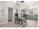 Bright dining area with wine rack and stylish light fixture, open to the updated kitchen with gray cabinets at 2016 Culberson Ave, Dunedin, FL 34698