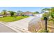 View of the home's long driveway leading up to a garage, with a well-maintained lawn and a mailbox in the foreground at 2016 Culberson Ave, Dunedin, FL 34698