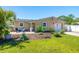 A well-kept front yard with lush lawn and landscaping, complemented by a charming home with a single-car garage at 2016 Culberson Ave, Dunedin, FL 34698