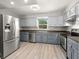 Well-lit kitchen with stainless steel appliances, two-tone cabinets, and wood-look floors at 2016 Culberson Ave, Dunedin, FL 34698