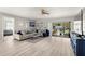 Bright living room featuring wood-look floors, a ceiling fan, and access to the screened porch at 2016 Culberson Ave, Dunedin, FL 34698