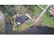 An aerial view of waterfront property with a home, mature trees and driveway parking for multiple vehicles at 2102 W Ivy St, Tampa, FL 33607