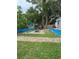 Lush backyard featuring an outdoor table and chairs with well maintained lawn and stone walkway at 2102 W Ivy St, Tampa, FL 33607