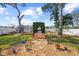 Landscaped backyard with lush lawn, mature trees, brick barbecue, and shed at 2940 Bay View Dr, Safety Harbor, FL 34695