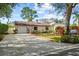 Charming single-story home with an attached garage, a well-manicured front yard, and mature landscaping at 2940 Bay View Dr, Safety Harbor, FL 34695
