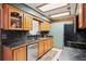 Kitchen featuring wooden cabinets, black countertops, tile flooring, and stainless steel appliances at 2940 Bay View Dr, Safety Harbor, FL 34695