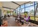Bright sunroom featuring brick floors, ceiling fan, and large windows overlooking the landscaped backyard at 2940 Bay View Dr, Safety Harbor, FL 34695