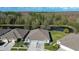 Stunning aerial view of a home with a well-manicured lawn, pond, and mature trees in the backyard at 31841 Larkenheath Dr, Wesley Chapel, FL 33543