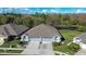 Stunning aerial view of a home with a well-manicured lawn, pond, and mature trees in the backyard at 31841 Larkenheath Dr, Wesley Chapel, FL 33543