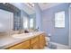 Bathroom features a large vanity with a single sink, oak cabinets, and neutral countertops at 31841 Larkenheath Dr, Wesley Chapel, FL 33543