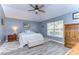 A bedroom with wood floors, a ceiling fan, and a large window for natural light at 31841 Larkenheath Dr, Wesley Chapel, FL 33543