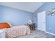 Bedroom featuring light blue walls, hardwood floors, and a quaint desk area at 31841 Larkenheath Dr, Wesley Chapel, FL 33543