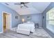 Well-lit bedroom featuring wood floors, a ceiling fan, and a bright window at 31841 Larkenheath Dr, Wesley Chapel, FL 33543