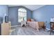 A bedroom with wood floors, a large window, and minimalist decor at 31841 Larkenheath Dr, Wesley Chapel, FL 33543