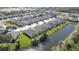 Aerial view of a residential community featuring well-maintained homes, streets, and a serene pond at 31841 Larkenheath Dr, Wesley Chapel, FL 33543