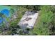 Overhead view of community sand volleyball court bordered by mature trees next to blue tennis court at 31841 Larkenheath Dr, Wesley Chapel, FL 33543