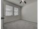 This bedroom is complete with plush carpet, a ceiling fan, and a large window with bright natural light at 3624 Autumn Amber Dr, Spring Hill, FL 34609