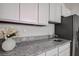 Kitchen featuring granite countertops, stainless steel refrigerator, and white cabinets at 3624 Autumn Amber Dr, Spring Hill, FL 34609