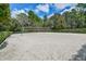 An empty outdoor sand volleyball court surrounded by green trees with the net in the center at 3624 Autumn Amber Dr, Spring Hill, FL 34609