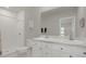 A bright bathroom with a double sink vanity and a stand-up shower with white tiles at 3664 Zephyr Preserve Pl, Zephyrhills, FL 33541