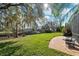Lush backyard with a pond view, manicured lawn, mature trees, and a patio seating area for outdoor enjoyment at 4110 Highland Park Cir, Lutz, FL 33558