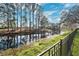 Scenic backyard with trees reflecting in the water, framed by a black metal fence at 4110 Highland Park Cir, Lutz, FL 33558