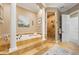 Elegant bathroom featuring a soaking tub, tiled shower, and decorative pillars at 4110 Highland Park Cir, Lutz, FL 33558