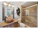Bathroom featuring double sink, granite countertops, decorative mirror and walk-in shower with glass door at 4110 Highland Park Cir, Lutz, FL 33558