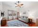 Bedroom with neutral walls, wood floors, ceiling fan, and large windows at 4110 Highland Park Cir, Lutz, FL 33558