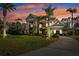 Elegant home featuring stately columns and lush landscaping at dusk at 4110 Highland Park Cir, Lutz, FL 33558