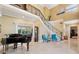 Grand foyer with black piano, ornate staircase, and marble floors under a soaring, two-story ceiling at 4110 Highland Park Cir, Lutz, FL 33558