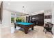 Billiards room with a large window overlooking the landscaped backyard and a built-in bar at 4110 Highland Park Cir, Lutz, FL 33558