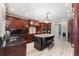 Elegant kitchen featuring dark wood cabinets, granite countertops, island, and stainless steel appliances at 4110 Highland Park Cir, Lutz, FL 33558