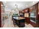 Elegant kitchen featuring dark wood cabinets, granite countertops, island, and stainless steel appliances at 4110 Highland Park Cir, Lutz, FL 33558