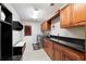 Laundry room with wood cabinets, black countertops, washer and dryer, and tile floors at 4110 Highland Park Cir, Lutz, FL 33558