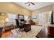 This home office offers a spacious layout with a ceiling fan, natural light, and a wooden executive desk at 4110 Highland Park Cir, Lutz, FL 33558