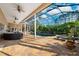 Covered lanai featuring an outdoor seating area and serene views of the pool and lush landscaping at 4110 Highland Park Cir, Lutz, FL 33558