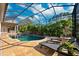 Beautiful pool with a rock waterfall feature and screened enclosure, surrounded by lush landscaping at 4110 Highland Park Cir, Lutz, FL 33558