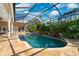 Sparkling pool with a rock waterfall and screened enclosure, set in a tropical backyard at 4110 Highland Park Cir, Lutz, FL 33558