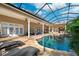 Stunning screened-in pool area featuring a waterfall, lounge seating, and lush landscaping at 4110 Highland Park Cir, Lutz, FL 33558