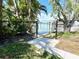 Waterfront view through a gated fence showing a private dock, and beautiful foliage on a sunny day at 619 59Th Ave, St Pete Beach, FL 33706