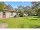 Rear exterior view showing the house and lush green lawn providing lots of space at 6524 Coronet Dr, New Port Richey, FL 34655