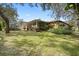 Spacious backyard featuring a screened-in porch, patio and lush greenery, perfect for outdoor relaxation and entertaining at 6524 Coronet Dr, New Port Richey, FL 34655
