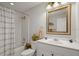 Bathroom featuring a shower-tub combo and a vanity with a framed mirror, exuding clean lines at 6524 Coronet Dr, New Port Richey, FL 34655
