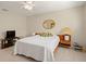Well-lit bedroom with a comfortable bed, ceiling fan, and round decorative mirror at 6524 Coronet Dr, New Port Richey, FL 34655