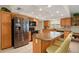 Well-lit kitchen with stainless steel appliances, a central island, and custom wooden cabinetry at 6524 Coronet Dr, New Port Richey, FL 34655
