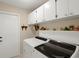 Laundry area with white cabinets and shelving above the washer and dryer at 6524 Coronet Dr, New Port Richey, FL 34655