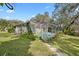 Back exterior view featuring screened-in pool, blending indoor-outdoor living in a lush setting at 6524 Coronet Dr, New Port Richey, FL 34655