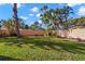 Expansive backyard featuring lush green grass and a privacy fence surrounded by mature trees at 6935 Date Palm S Ave, St Petersburg, FL 33707